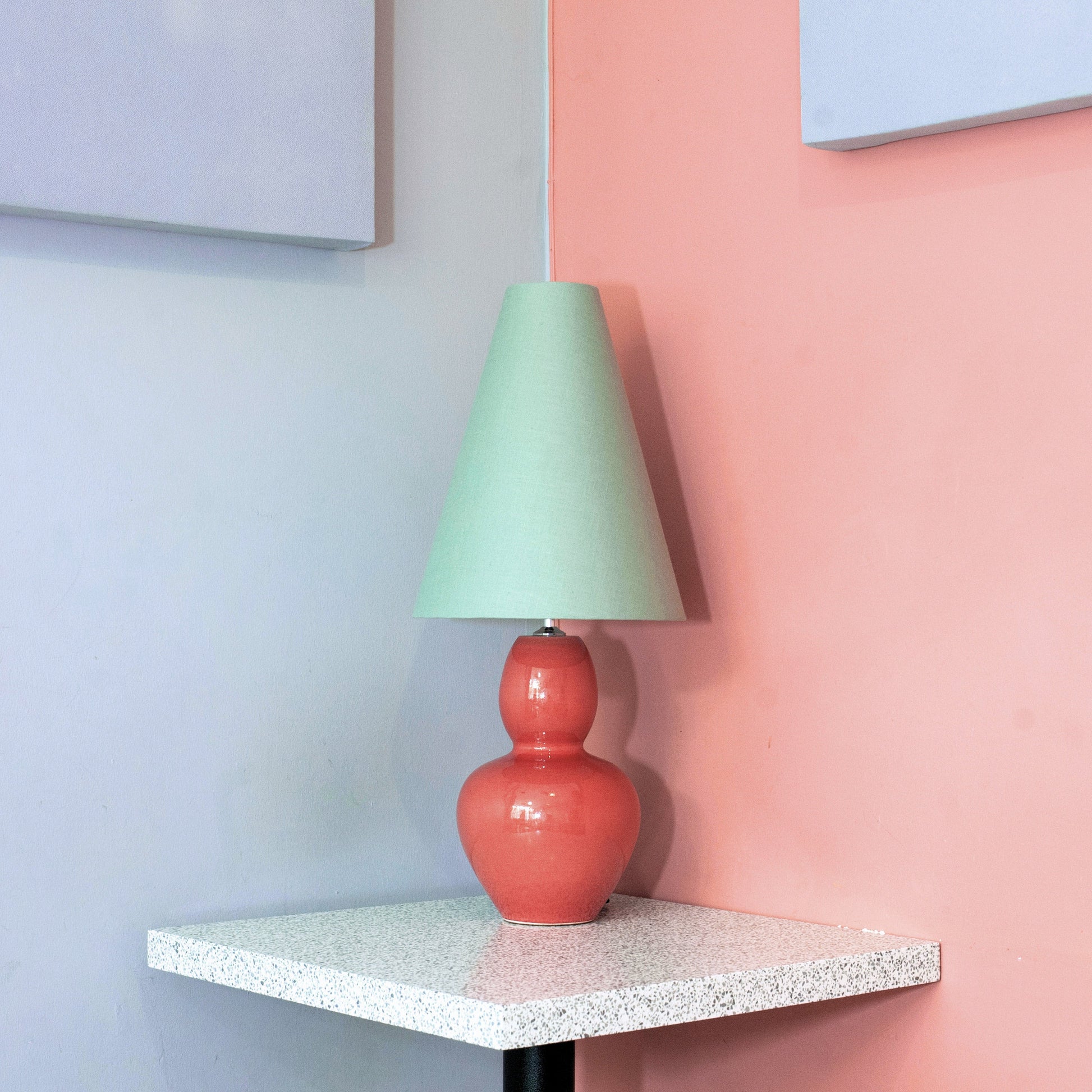 Colorful lamp on a small table against a pastel wall